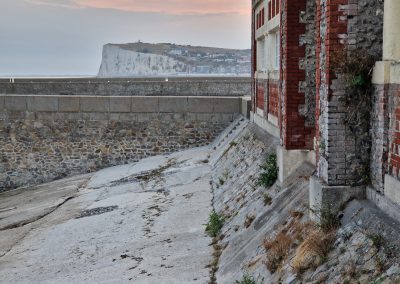 Steilküste bei Le Tréport vom Hafen ausgesehen. Rechts im Bild die Wand des Fischhandelsgebäudes